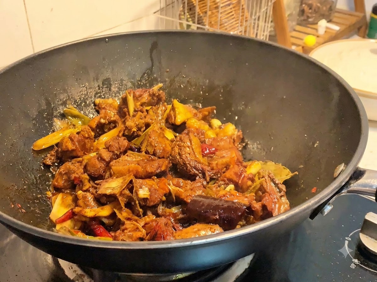 強火で加熱され、ソースがとろりと煮詰まっていく中華鍋の中の鴨肉。