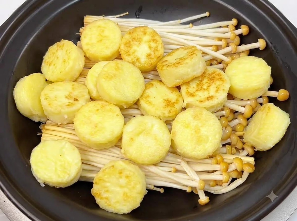 土鍋の中のえのき茸の上に、きつね色に焼けた卵豆腐の輪切りがきれいに並べられている様子