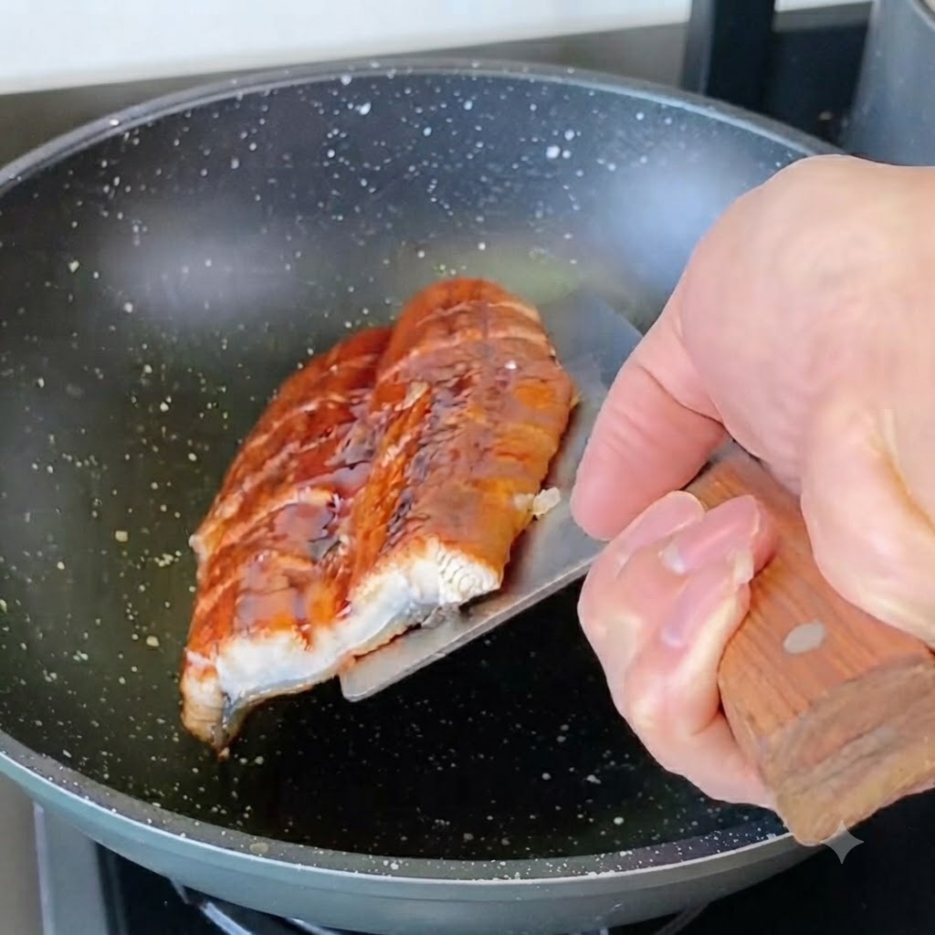 切ったうなぎをフライパンで軽く焼いている様子。