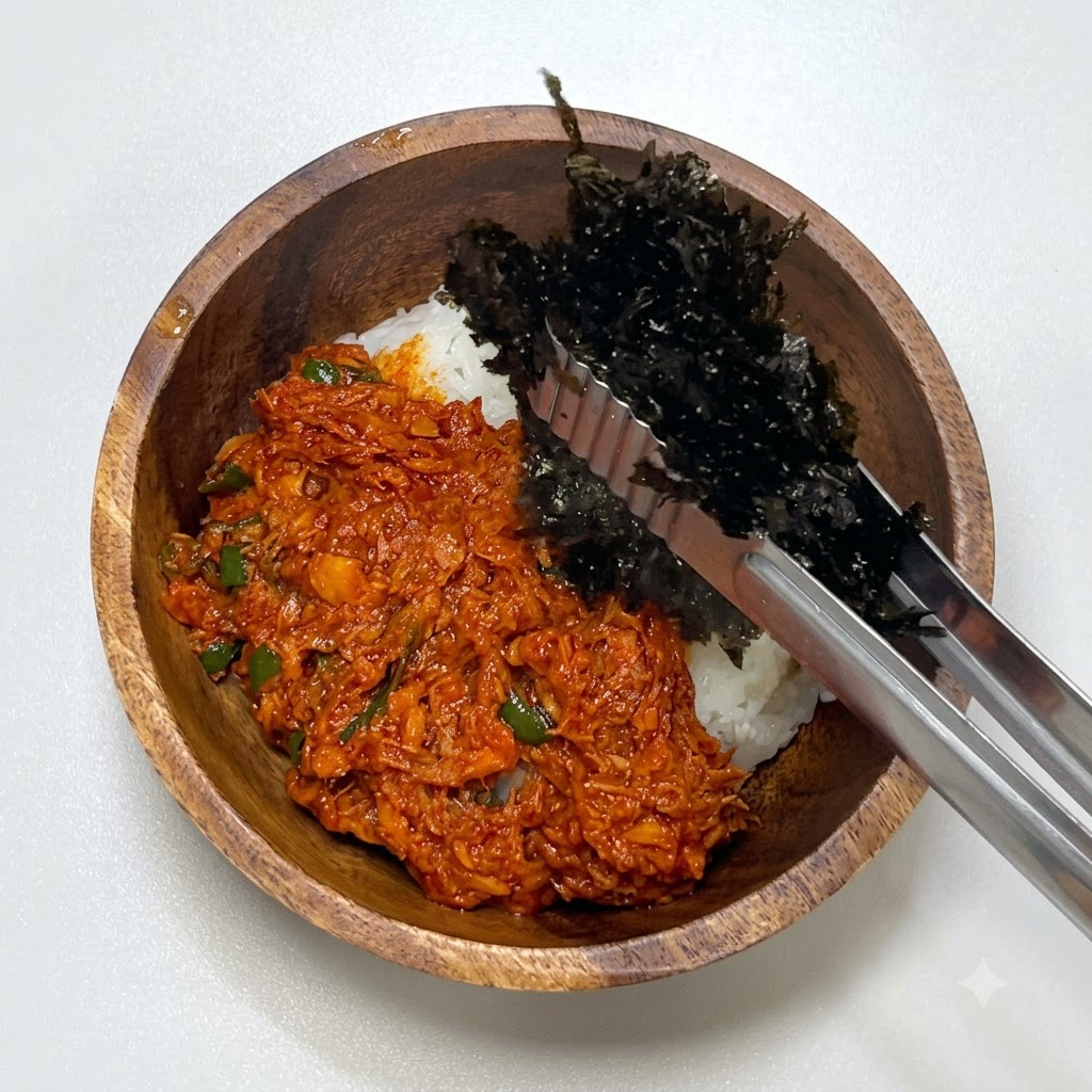 トングを使って、スパイシーツナの横にたっぷりのもみ海苔を添えている様子。