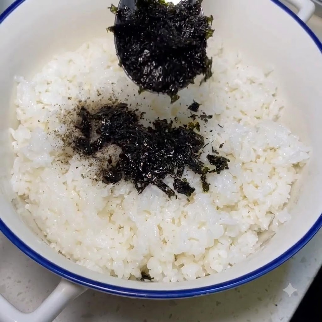 炊き立ての白米にふりかけられる海苔粉