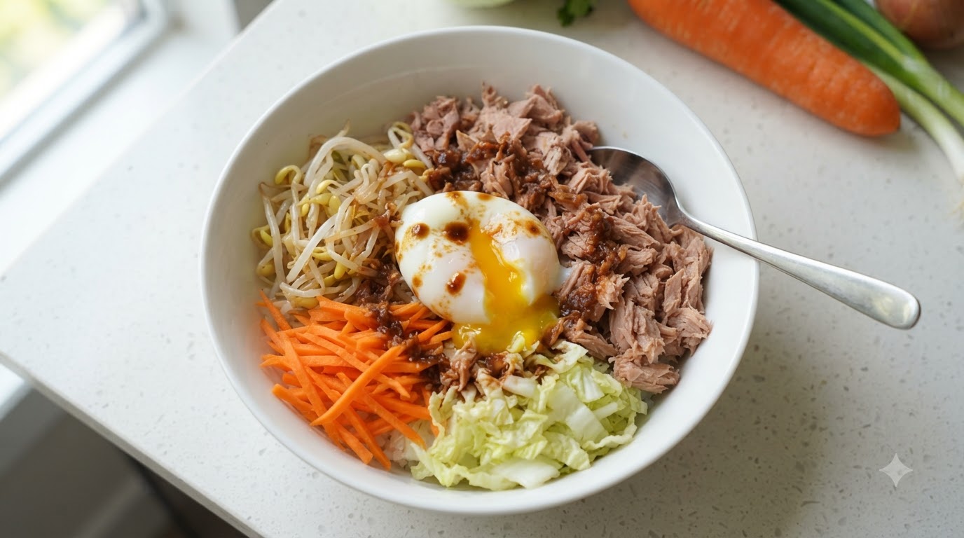 半熟卵、ほぐしたツナ、野菜、特製ダレをトッピングした色鮮やかなツナ混ぜご飯