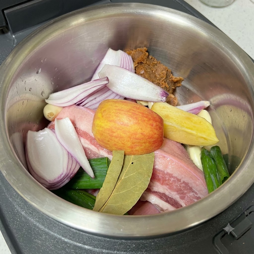 炊飯器の中の具材と味噌の上に塩を挽いてかけている様子。