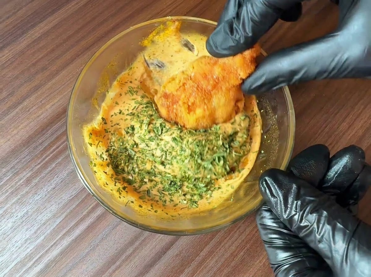 完成したバーガーソースのボウルの上に、細かく刻んだ新鮮なパセリが振りかけられ、フライドフードの断片がそれにディップされているところ。